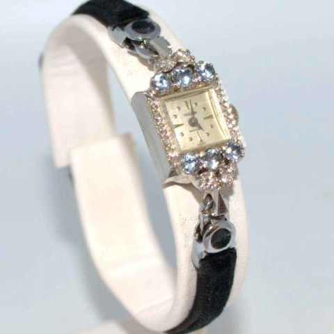Lady's 14kwg Gruen diamond watch: Lady's 14kyg Gruen diamond watch 3.7gr with square white face,17 jewel movement, 4 prong set diamonds .20ctw, along with 6 prong set aquamarines and felt band. Good working condition.