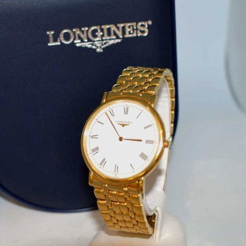 Man's goldstone Longines watch: Man's Longines gold tone watch with white roman dial, Swiss quartz movement and heavy gold plated panther band. Comes with box and papers.