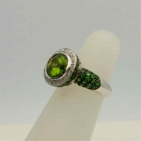 14kwg peridot & tsavorite ring: 14kwg peridot & diamond ring 6.2gr, oval shaped peridot weighing approx. 2.50ct, surrounded by prong set diamonds, and tsavorite garnet on the shoulders and under carriage, finger size 5.