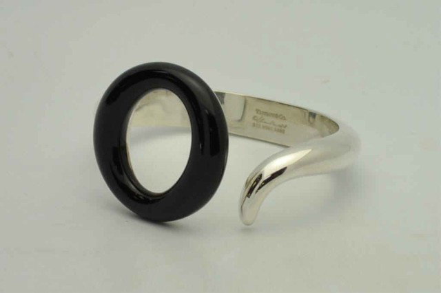 Sterling & onyx bracelet by Tiffany & Co: Sterling & onyx bracelet by Elsa Peretti for Tiffany 1.5oz, circular black onyx with spring action opening.