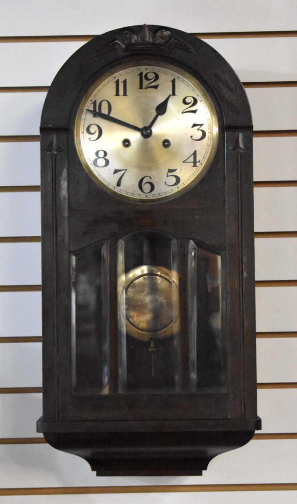 Antique Wall Clock: Antique Wall Clock. Stands 25" in height. Mahogany finish to the wall clock. Comes with a pair of keys. Painted zinc numeral dial. Hand written Instructions on how to reset the clock and reset th cloc