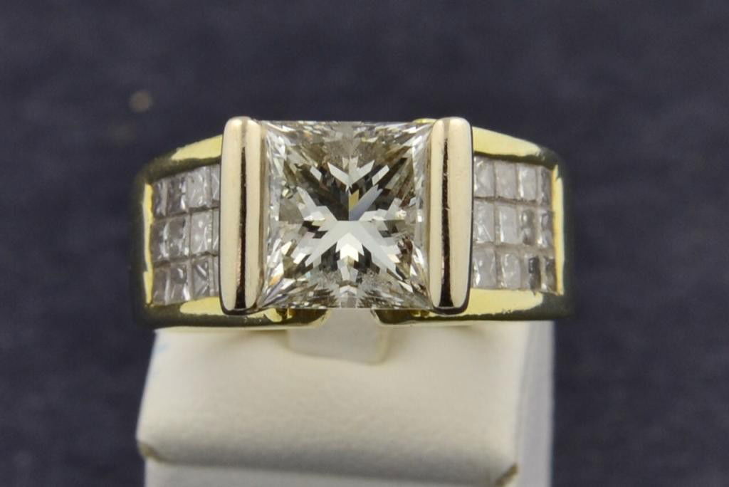 18k yg 4 1/2 ct Lady's Princess Ring: 18k yg 4 1/2 ct Lady's Princess Ring. The center weighs 3.19ct and is 8mm wide. Clarity VS, Color L. 30 Invisible set Princess on the shoulder. 1.50ctw. Clarity VS, Color I, size 7, 14.1gr