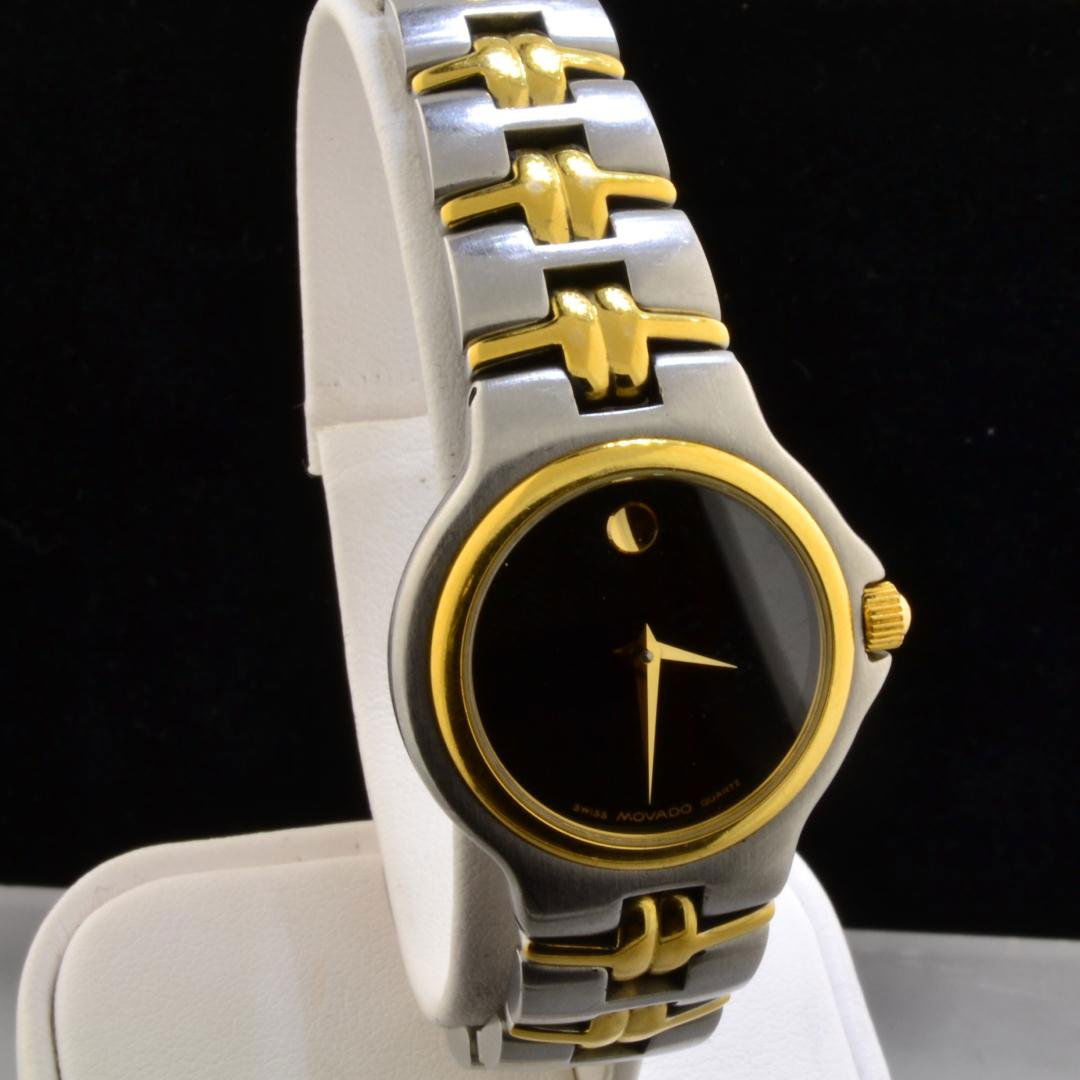MOVADO Two Tone Lady's Watch: MOVADO Two Tone Lady's Watch. Swiss Quartz movement and black dial. 25mm case