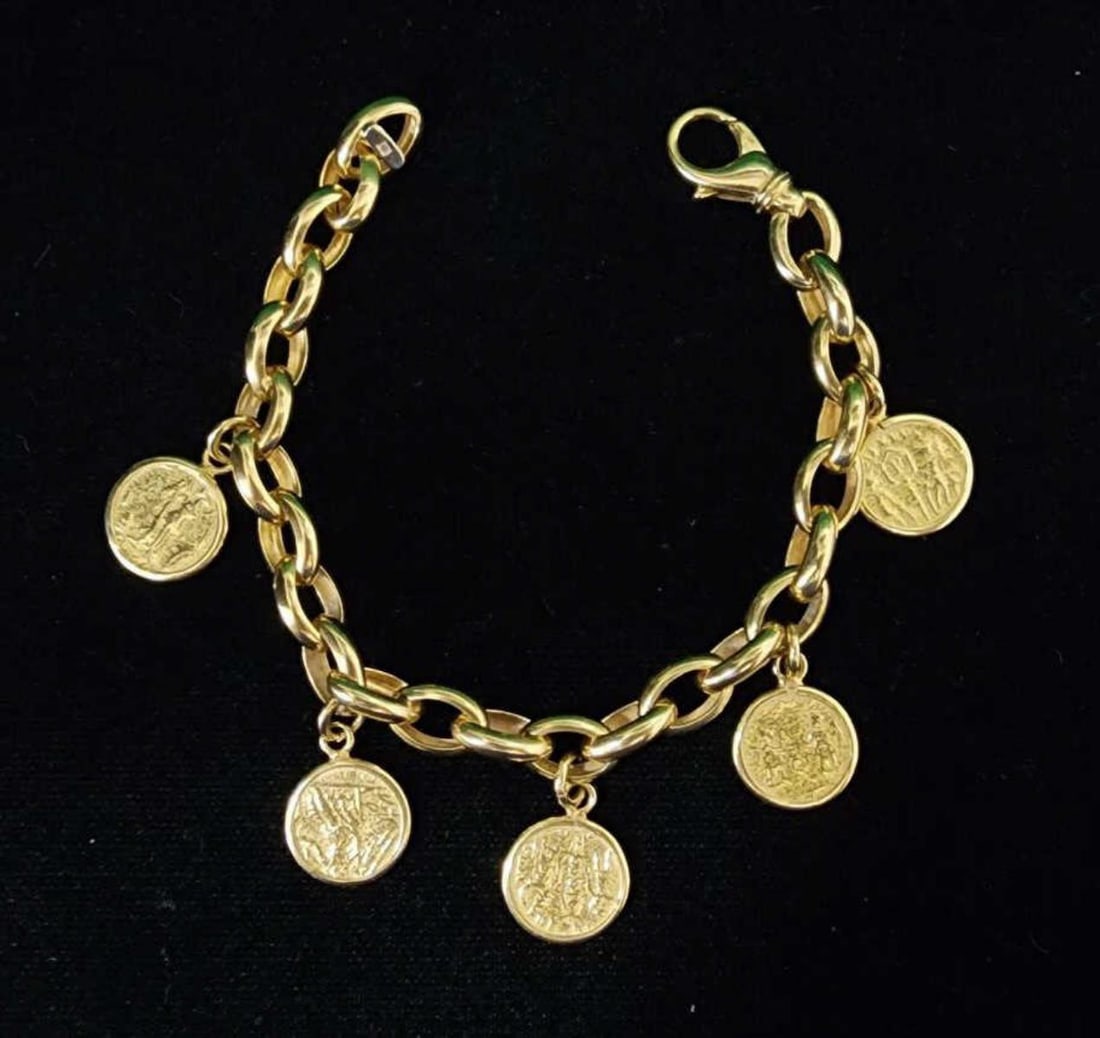 18kt yellow gold replica coin bracelet: Ladies 18kt yellow gold replica coin bracelet featuring an oval rolo style link accented with replica ancient coin style charms. Finished with a heavy lobster clasp. Length 7.5". Weight 30.7 grams