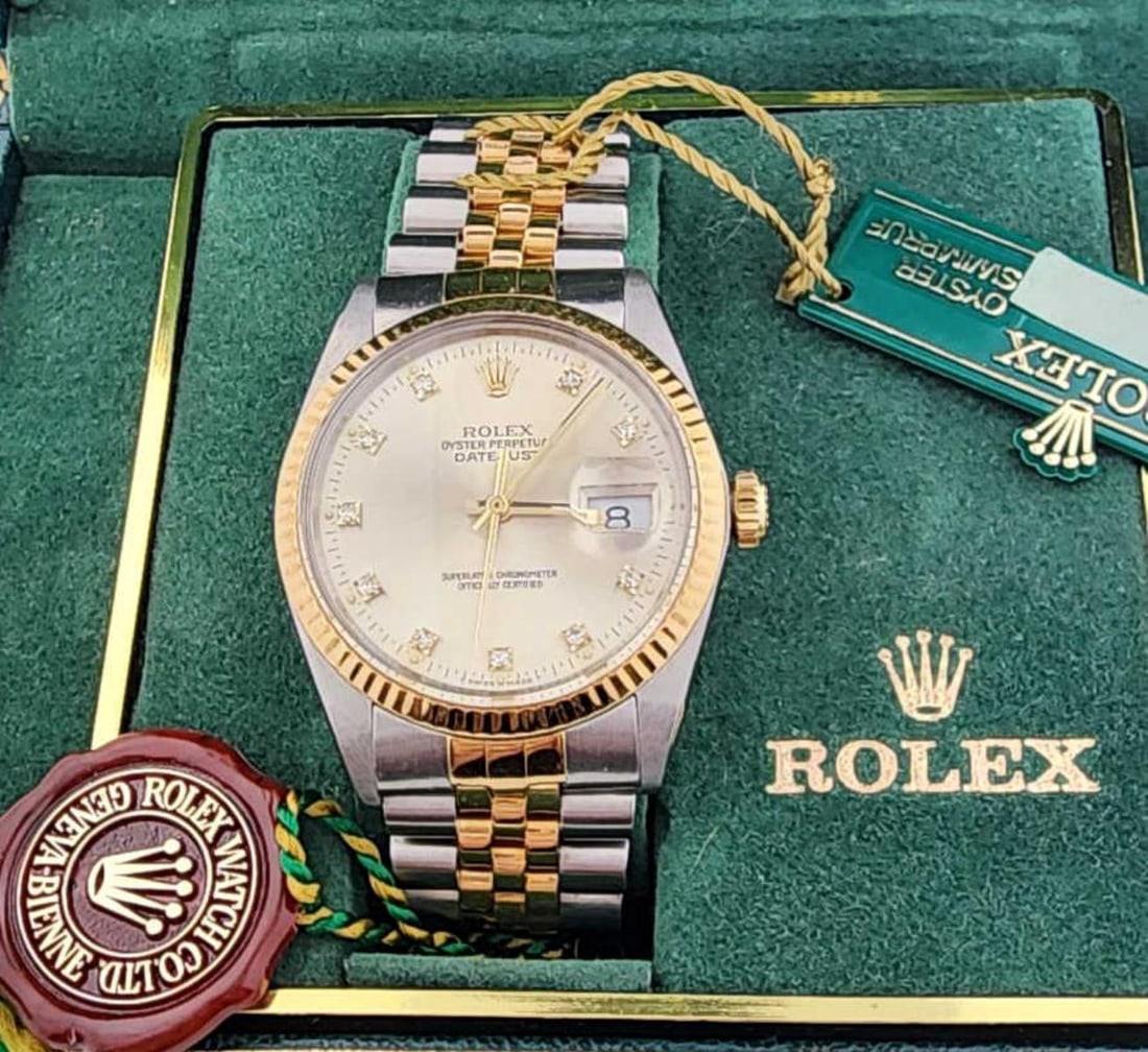 Men's two tone Rolex Datejust watch: Men's 18kt and stainless steel Rolex Datejust watch , model # 16013, featuring a silver toned dial with diamond markers, acrylic crystal, fluted bezel, jubilee bracelet and automatic movement. Yr. 198