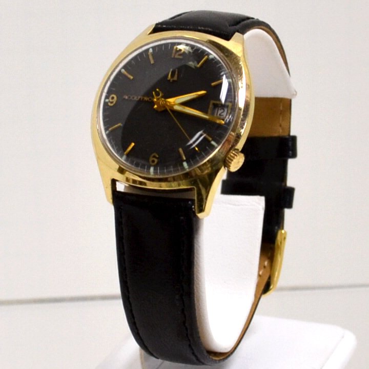 Man's Bulova Accutron Tuning Fork Watch: Man's Bulova accutron watch with charcoal dial and date, quartz movement with tuning fork, 14k gold filled case and new band.