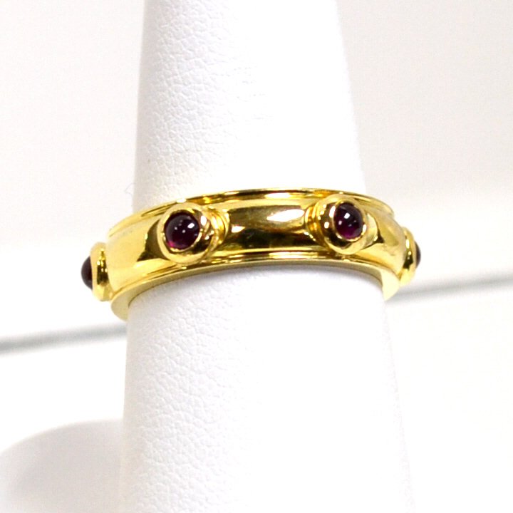 18kyg Ruby Ring by Tiffany & Co: Lady's 18kyg ruby stacking ring with 6 bezel set cabochon rubies 2mm in diameter, 5mm band by Tiffany, finger size 71/2. 6.4gm