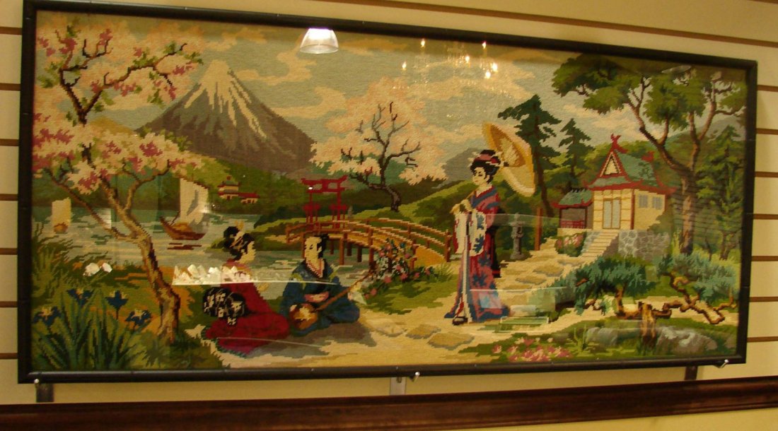 Vintage Needlepoint of a Japanese Scene: Vintage Needlepoint of a Japanese Scene featuring 3 figures by a lake with a pagoda and Mt. Fuji in the background; framed under Plexiglas, 45 x 20"."
