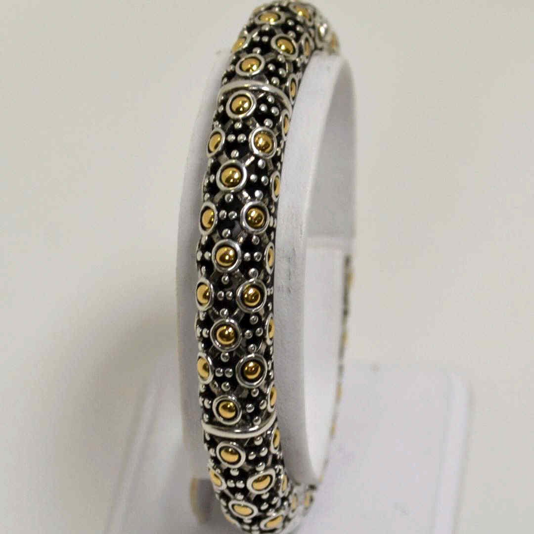 John Hardy 18k & Sterling Bracelet: John Hardy bangle bracelet with 18kyg and circular designs , 10mm in width and 21/2 inside diameter."