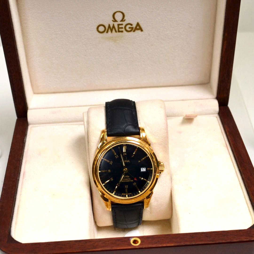 18kyg Omega Deville Co-Axial Watch: Man's 18kyg Omega Deville Co-Axial automatic chronometer with black dial and gold hands, date, Swiss automatic movement and original black leather band. Never been worn. Comes with box, manual and car