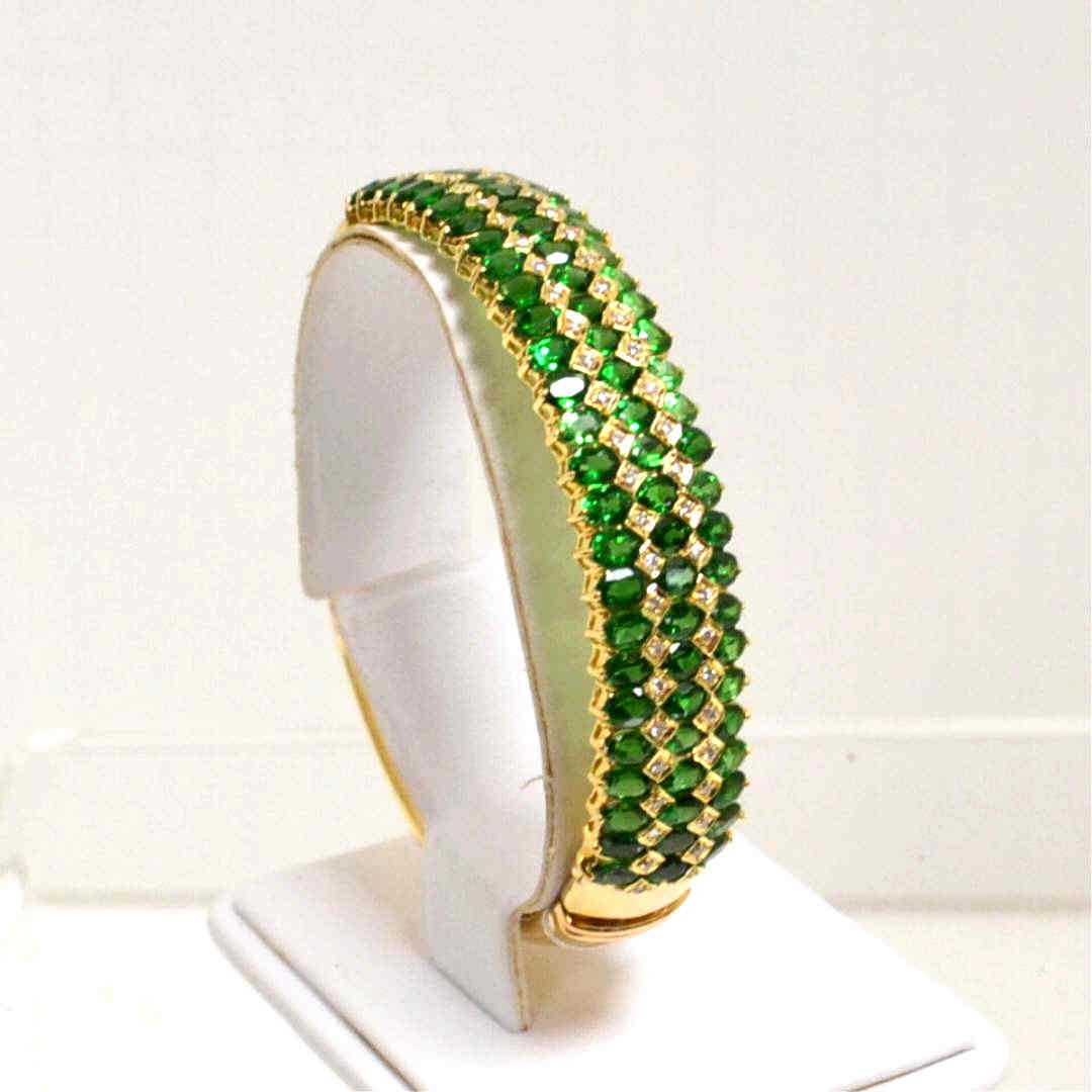 14kyg Tsavorite & Diamond Bracelet: Lady's 14kyg tsavorite and diamond bracelet with 78 oval shaped tsavorite weighing approx. 25cts alternating with prong set diamonds 1ctw, 10mm wide with under safety clasp. 34.2gm 12940
