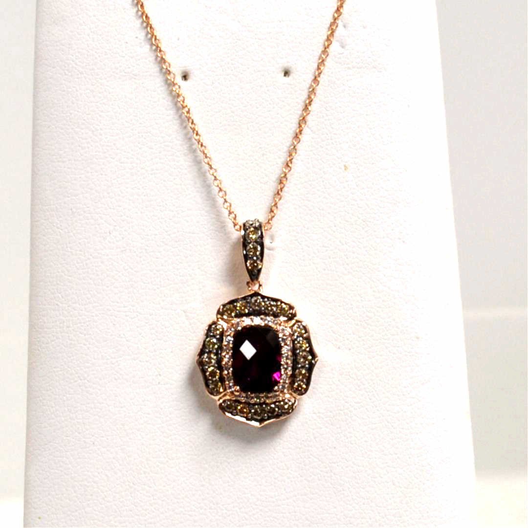 14k LeVian Garnet & Diamond Ring: 14k rose gold LeVian garnet and diamond pendant with checker top rhodolite garnet measuring 8x6mm surrounded in prong set white and chocolate diamonds weighing approx. .75ctw and 18" link chain. 5gm