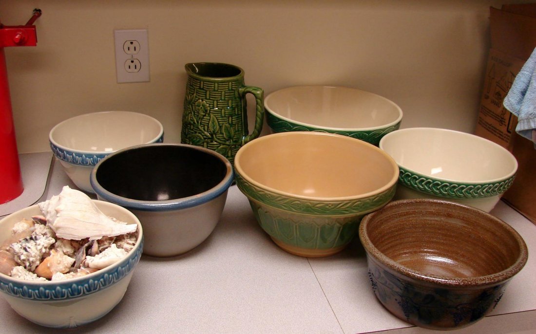 7 Pottery Bowls, Rowe, Longaberger, Over & Back Y: 4 Longaberger Bowls, one filled with Florida sea shells, 1 Over & Back Yellow Ware bowl, one brown & blue pottery bowl, one Rowe bowl ; one green majolica pitcher; no chips.
