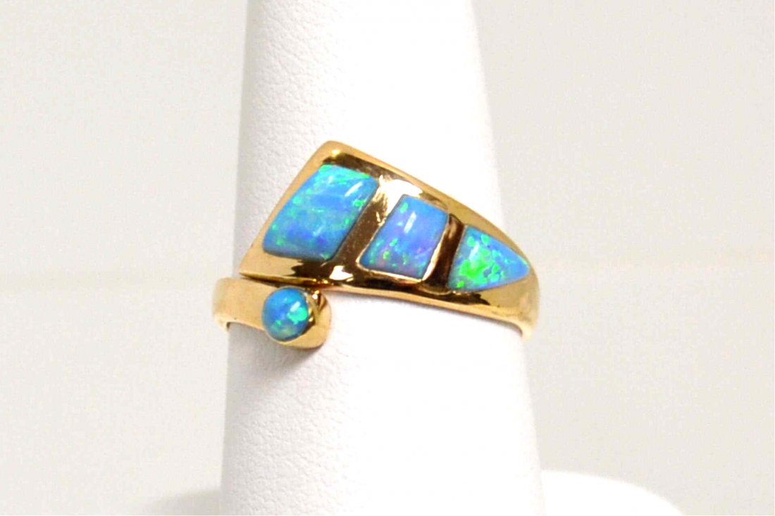 14kyg opal Ring: Lady's 14kyg opal ring with 4 geometrically cut opals with blues and greens in a bypass design, finger size 7 1/2. 3gm