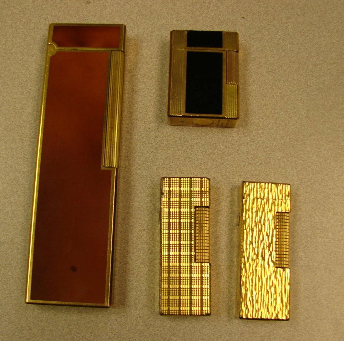 2 S. J. Dupont Lighters & 2 Dunhill Lighters: 2 S. J. Dupont Lighters, one is 5.5" long (some scratches on finish) & 2 Gold filled Dunhill Lighters, one missing screw. Dunhill offers lifetime service on their lighters.
