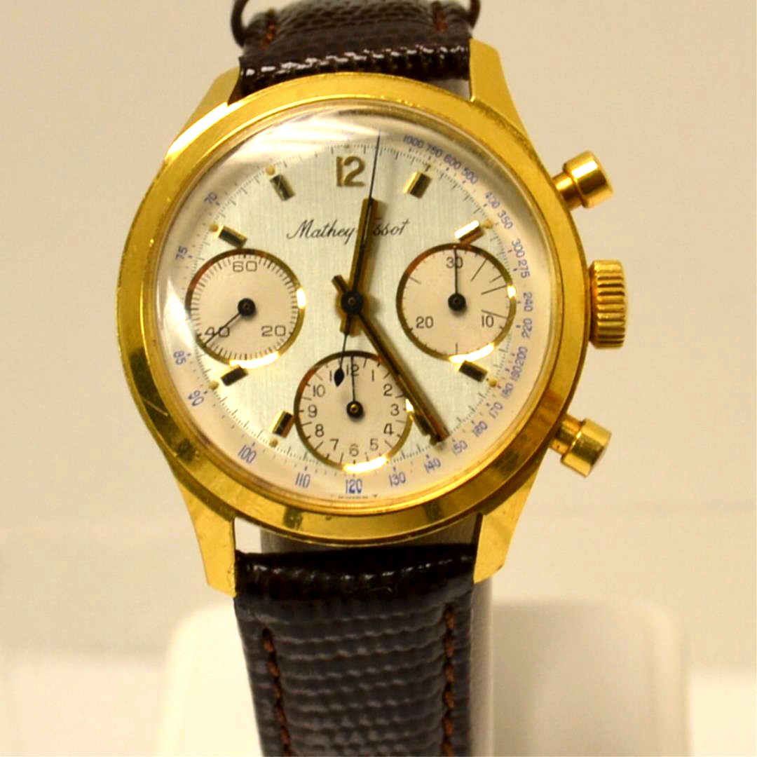 18kyg Mathey Tissot Chronograph Watch: Vintage 18kyg Mathey Tissot chronograph watch with gray dial and white sub dials, mechanical wind up movement, 35mm case and good running condition. (some scratches & dents on back) New leather band.