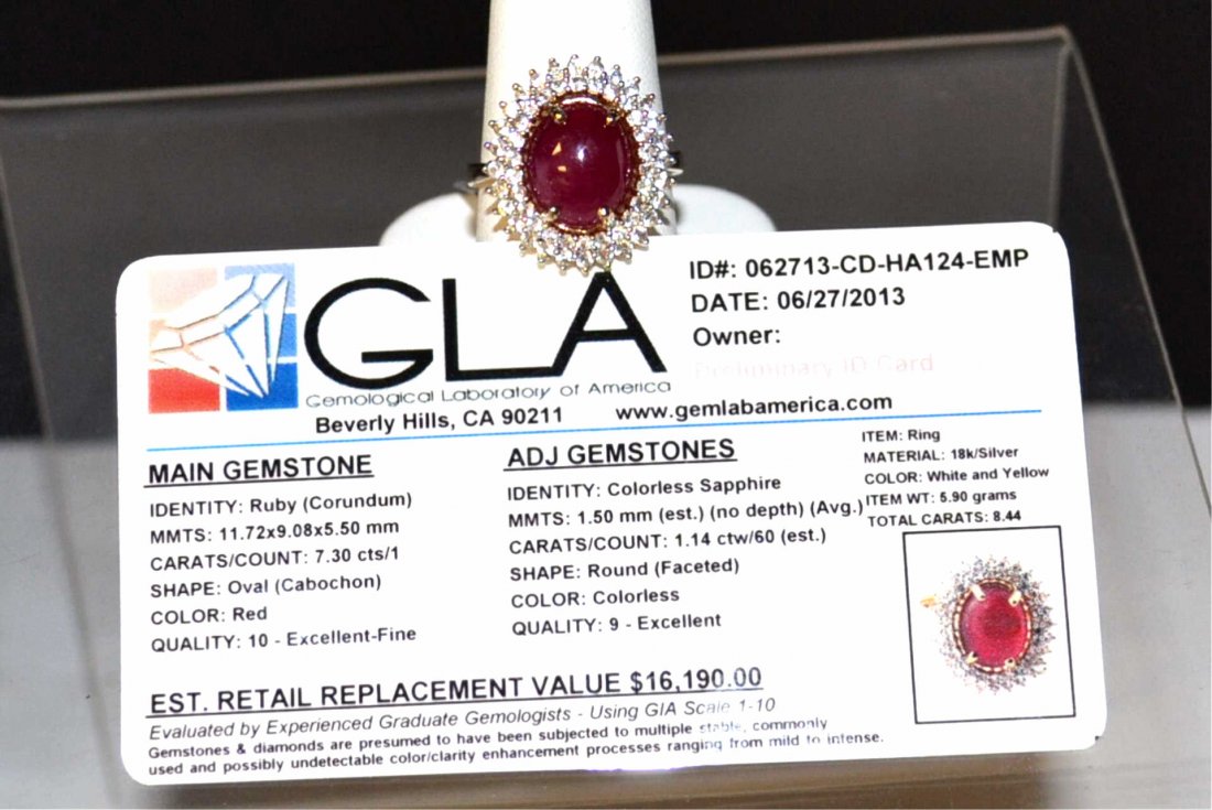 Sterling Natural Cabochon Ring: Sterling silver mounting with yellow gold overlay containing oval shaped cabochon ruby weighing 7.30ct surrounded by 2 rows of prong set white sapphires, 1.14ctw, finger size 8. GLA appraised. K29J1