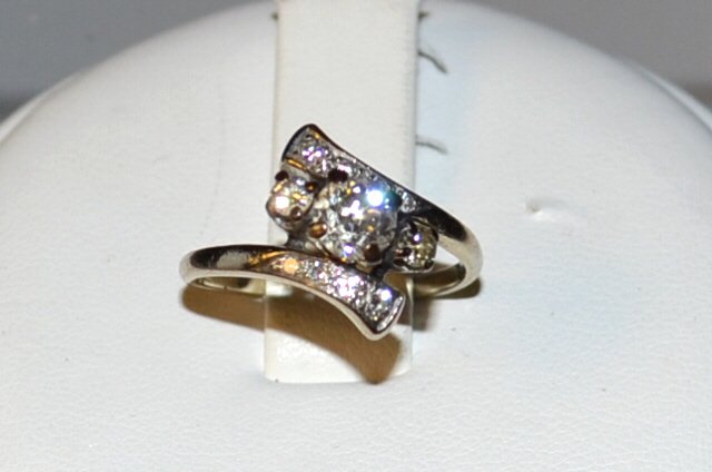 Vintage 14kwg Diamond Ring: Vintage 14kwg diamond ring with three prong set diamonds, center, weighing approx. .40ctw, along with prong set diamonds in bypass design, .24ctw, finger size 7 1/2. 3.7gm