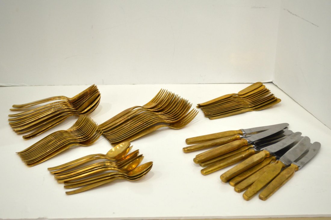 Set Of Gold Metal Flatware: Set Of Gold Metal Flatware. German made by Aureal, service for twelve. Dinner knives, 8 1/4"l., dinner forks, 7 1/4"l., salad forks, 6"l., table spoons, 7"l., tea spoons, 5 3/4"l., and butter knives,
