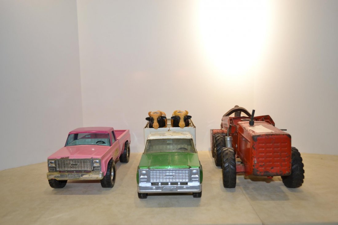 lot of toy trucks: lot of toy trucks. Nylint kennels pickup truck. Exterior of truck is pink. Nylint farms farms pickup truck w/2 original cows. Exterior color is green with white roof. Nylint payloader. Red exterior co