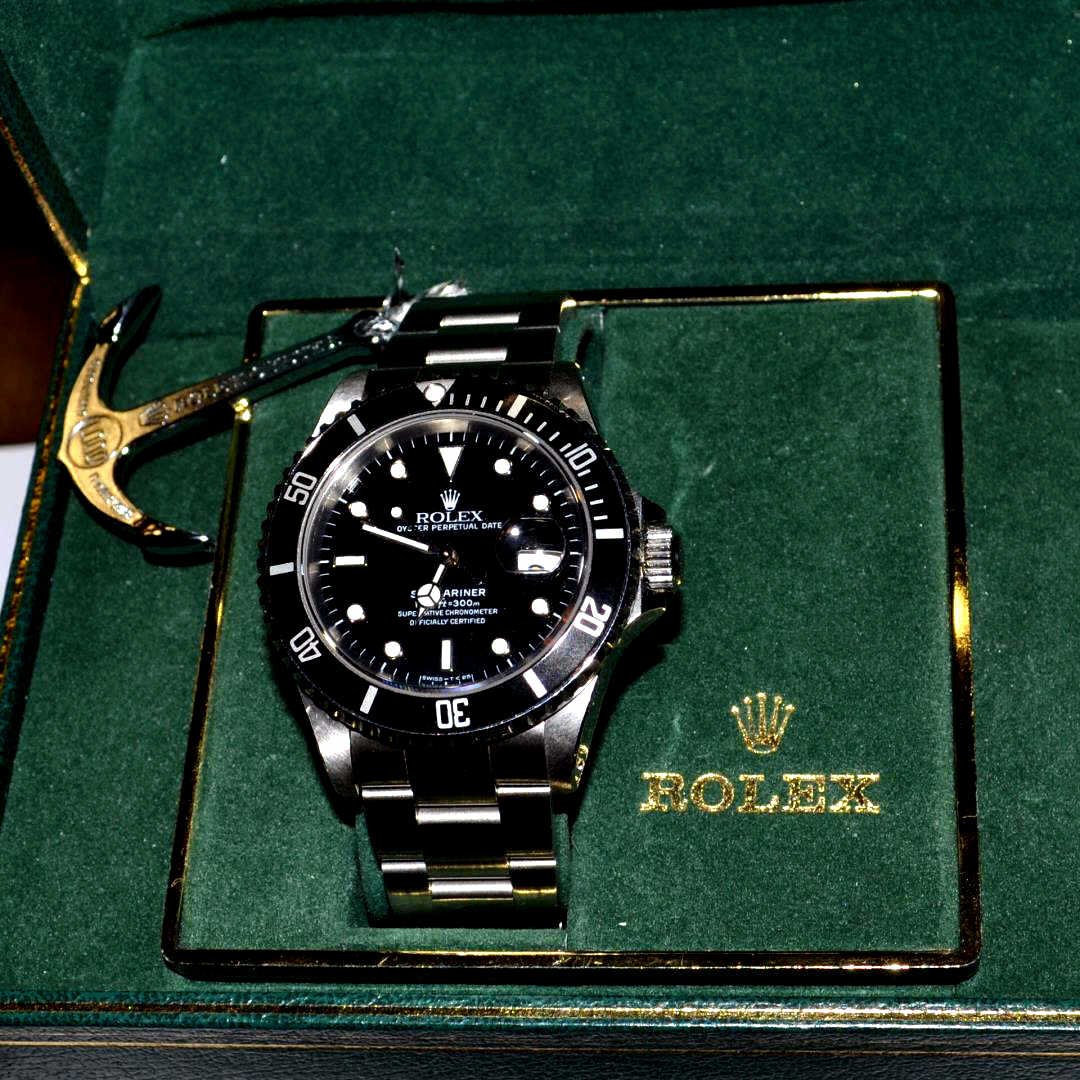 Man's Stainless Rolex Submariner: Man's stainless Rolex Submariner with black dial and bezel, date, sapphire crystal, waterproof to 300m and oyster band. Comes with box and papers. 89
