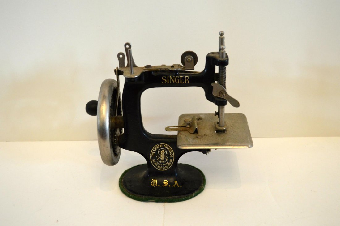 Child's Singer Sewing Machine: Child's Singer Sewing Machine. Black enameled sewing machine with gold decals, 6 1/2"h. Some wear.