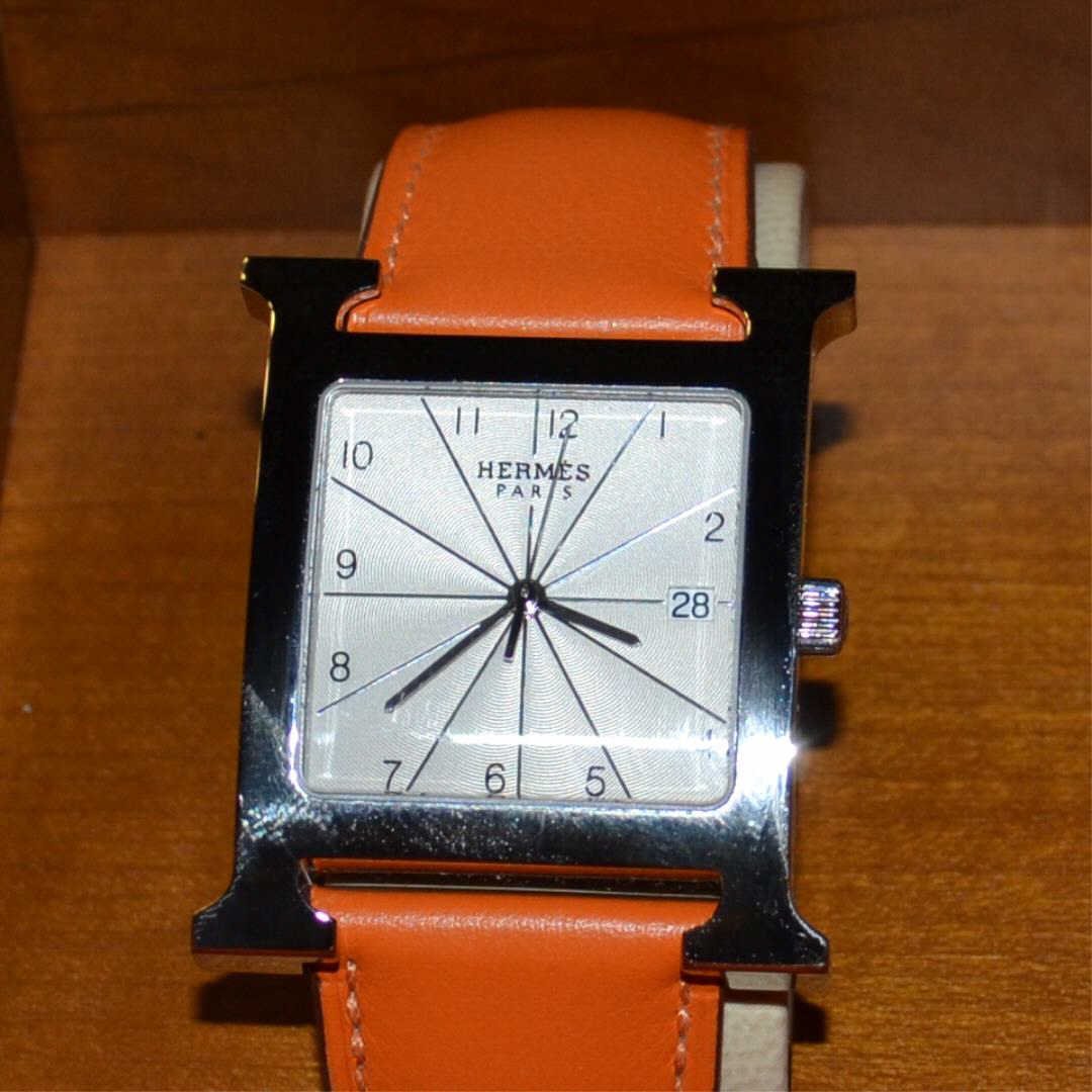 Hermes Stainless "H" Watch: Hermes stainless "H" watch model #HH1 810 with white dial, calendar, Swiss movement, water resistant, sapphire crystal, orange calfskin leather band and never been worn. Comes with original box.