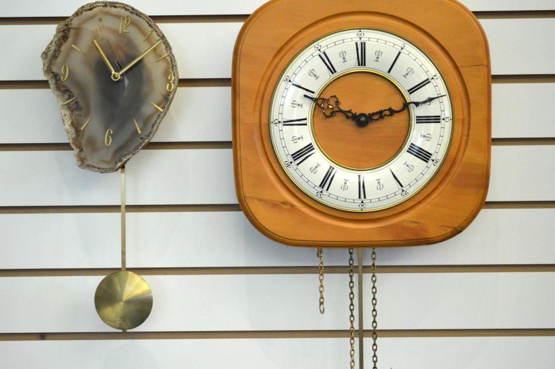 Two Wall Clocks: Two Wall Clocks. A weight driven clock in yellow wood with faux porcelain dial, includes weights and pendulum, 11 1/2"h., and a battery power clock built into a geological specimen, includes pendulum,