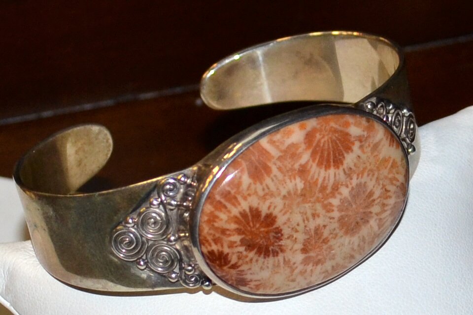 Sterling Sajen Cuff Bracelet: Sterling cuff bracelet by Marianna Sajen with oval shaped floral stone with carnelian color, bezel set with filigree on either end, 20mm tapered with 2 3/4 inside diameter.