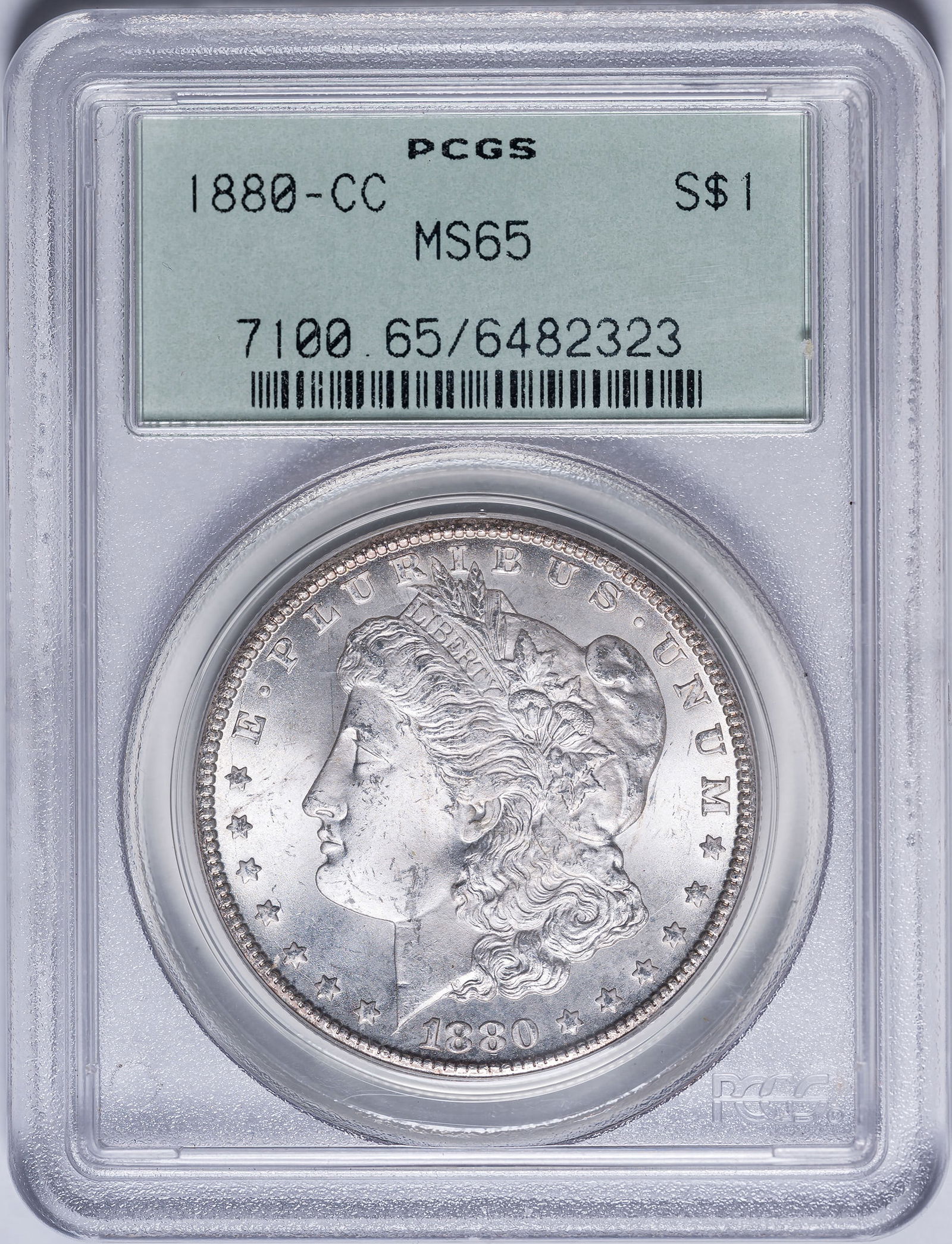PCGS MS-65 1880-CC Morgan Dollar: A frosty and brilliant Gem with intense cartwheel luster. In an old-style green label PCGS holder with plastic frame.