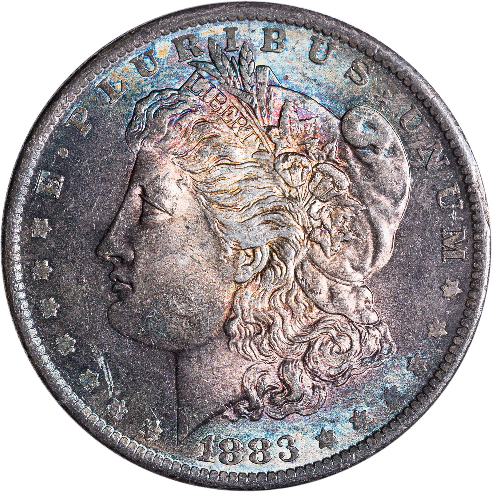 MS-62 to 63 Toned 1883-O Morgan Dollar: Vividly toned in gun-metal blue and rose throughout the obverse, largely brilliant with a faint rainbow glow at the reverse rim.