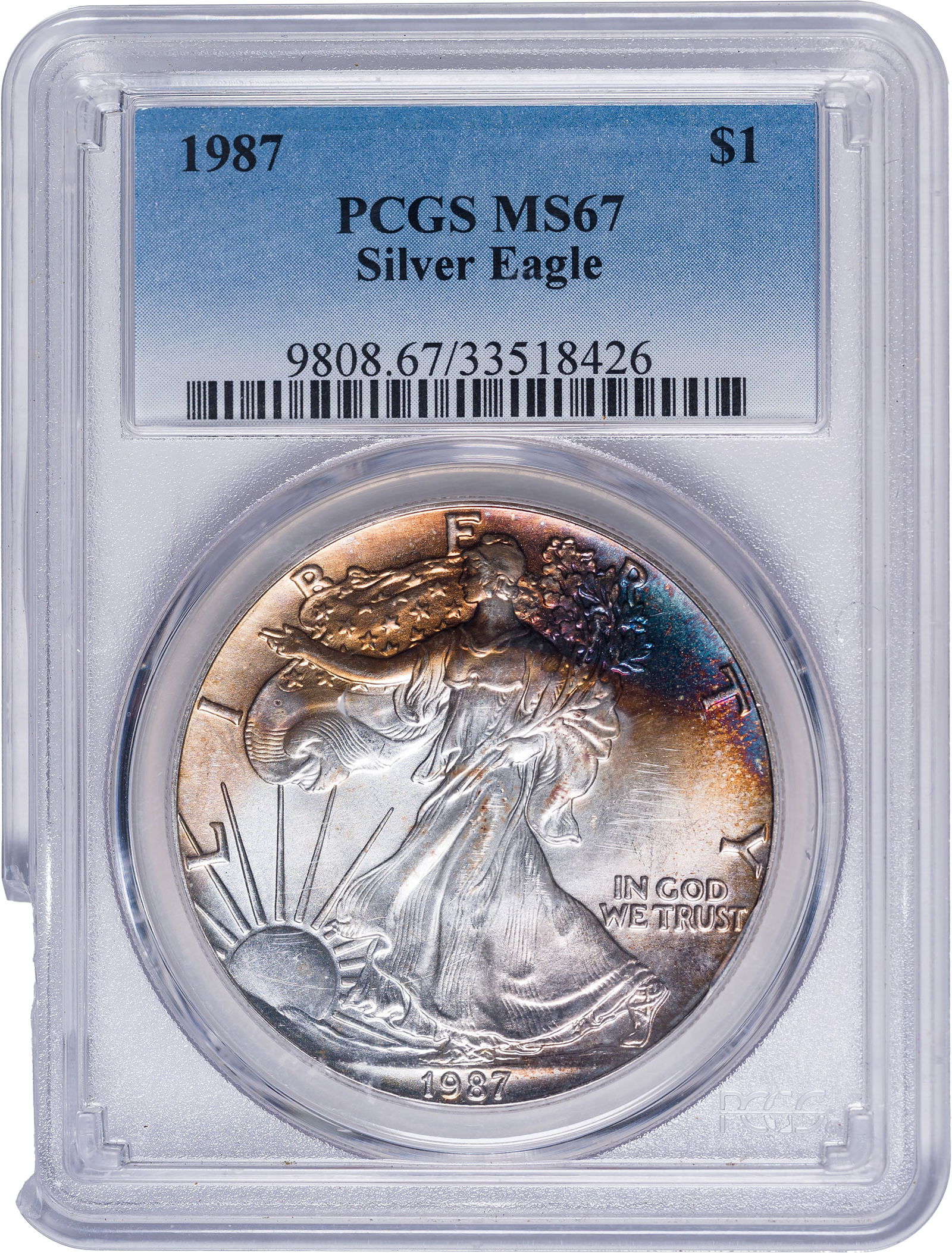 PCGS MS-67 Toned 1987 American Eagle Dollar: A crescent of vivid toning, chiefly crimson and gold, adorns the top portion of the obverse.