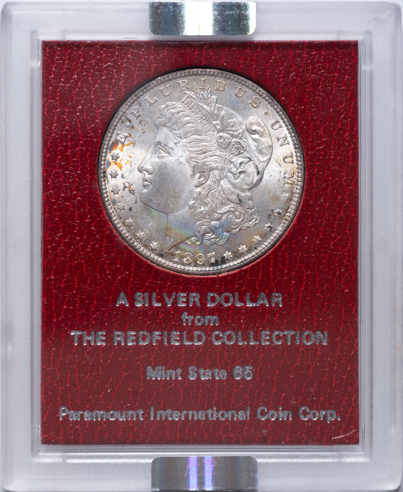 NGC MS-65 1897 Redfield Hoard Morgan Dollar: Shows some mottled but not unattractive obverse tone. Housed in an NGC banded Paramount holder.