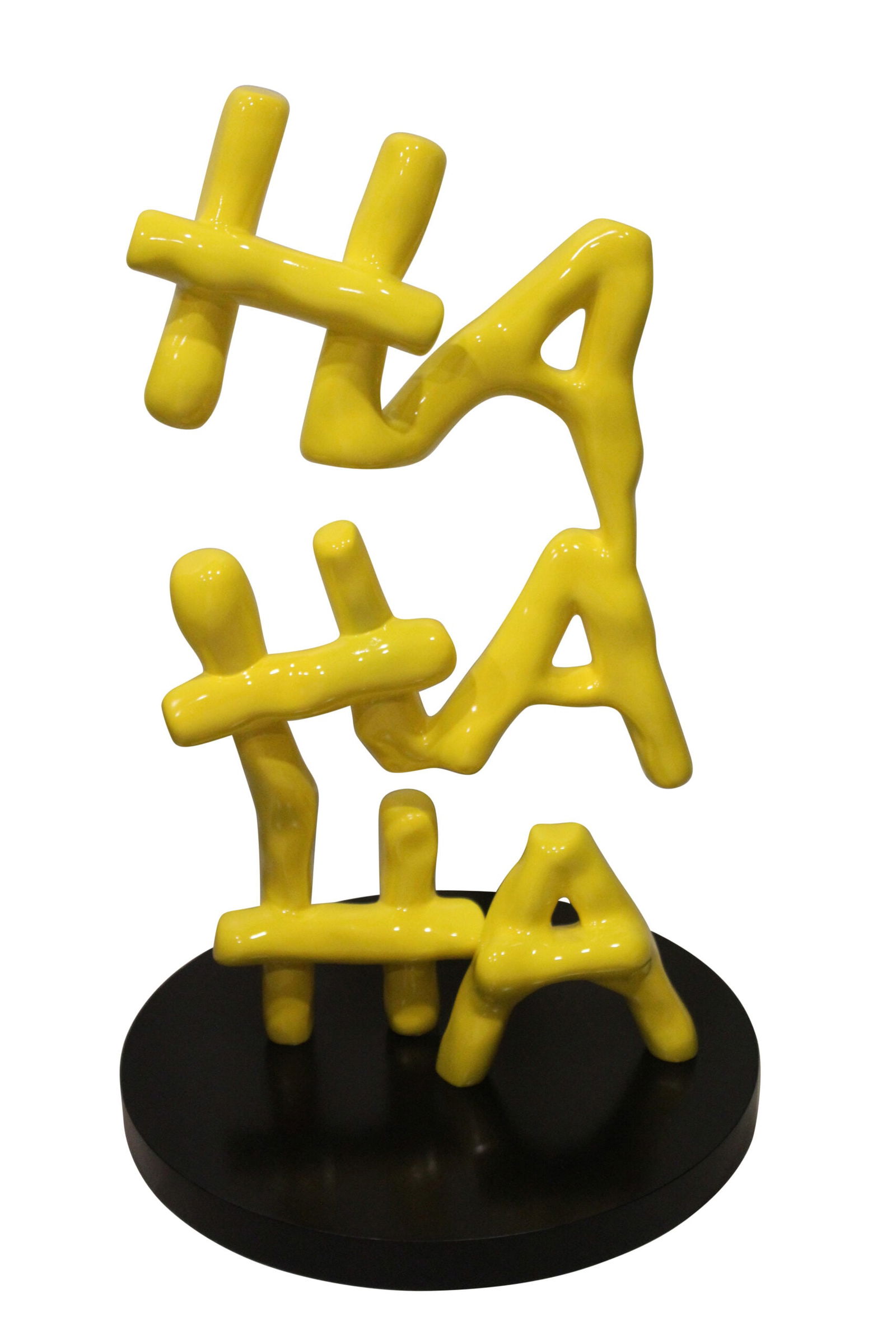 Yellow Pastel HA HA HA Resin Statue on Black Metal Base 20" x 20" x 31"H: Elevate your space with a captivating resin statue that has HA HA HA written in yellow in a young font. Sitting atop a sleek black metal foundation base, it creates a visually striking and contemporar