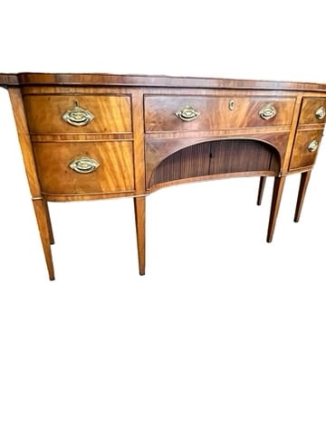 GEORGE III MAHOGANY SIDEBOARD LATE 18th CENTURY: George III English late 18th century mahogany sideboard featuring a bowed rectangular top drawer over a long drawer over a recessed tambour door flanked by a deep drawer and a hinged door with sham dr