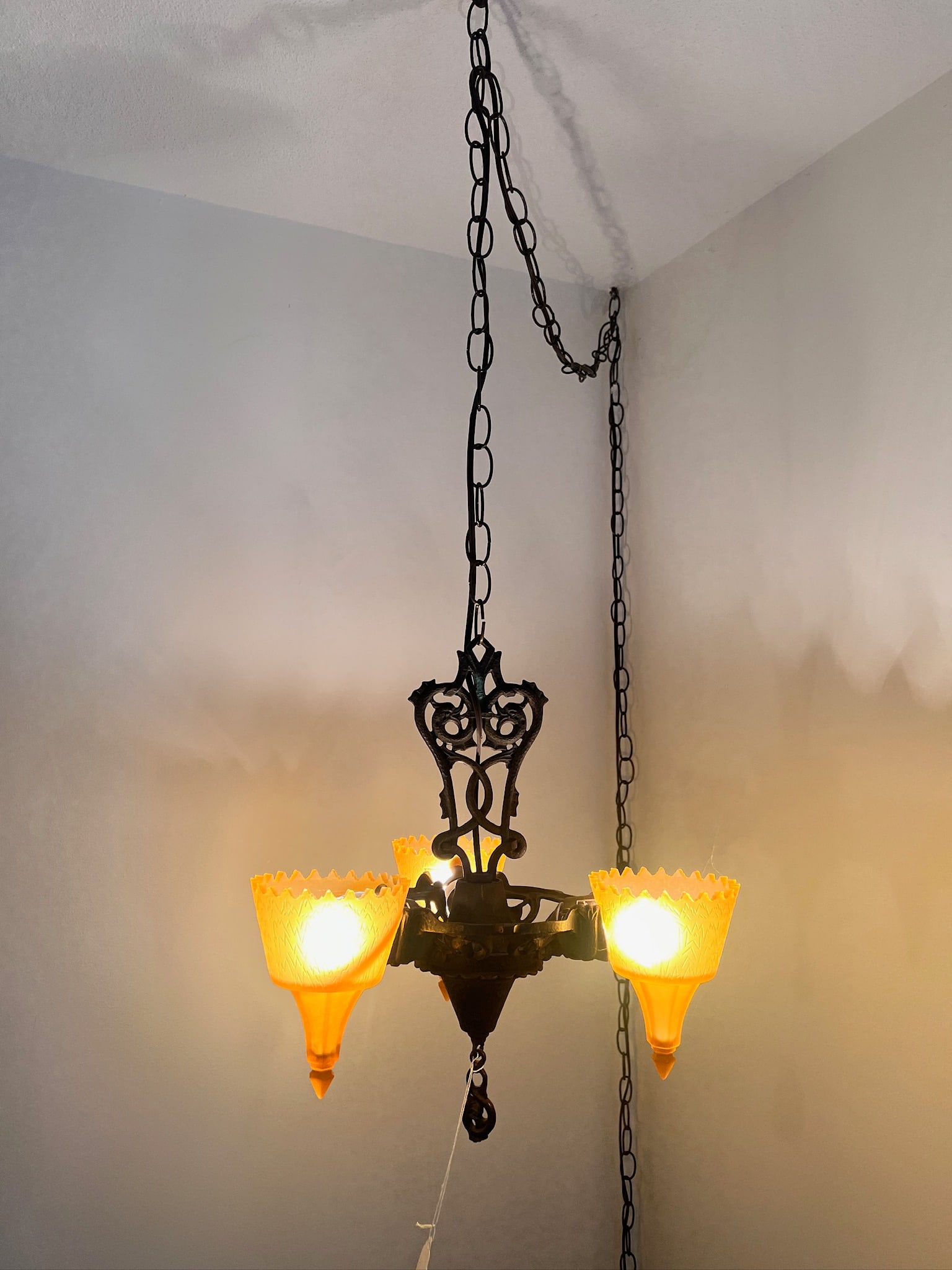 Art Deco Slip Shade Chandelier Cast: Detailed, heavy cast slip shade Art Deco chandelier. Piece is decorated with a stylized serpent detail, amber glow/yellow glass shades. Wired for plug in and in working condition. Measures 14 inches w