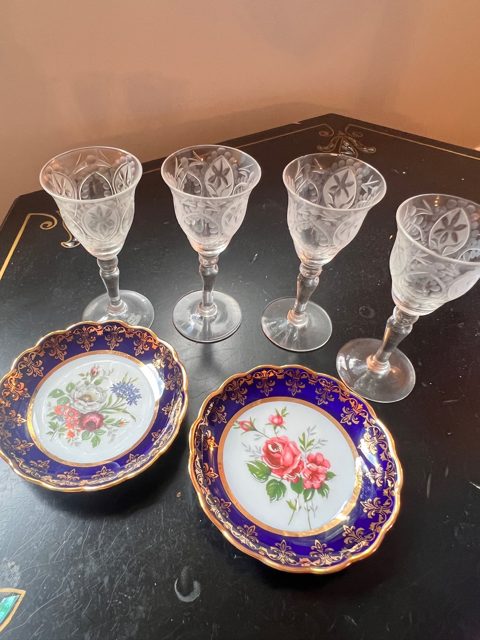 6 Piece Lot Limoges and Crystal Serve-ware: 6 Piece lot of serve-ware. 2 Limoge butter pats detailed with roses in the center and gold leafing around the edge. 4 crystal cordials, unmarked, with 2 cordials that each have a small chip on the rim