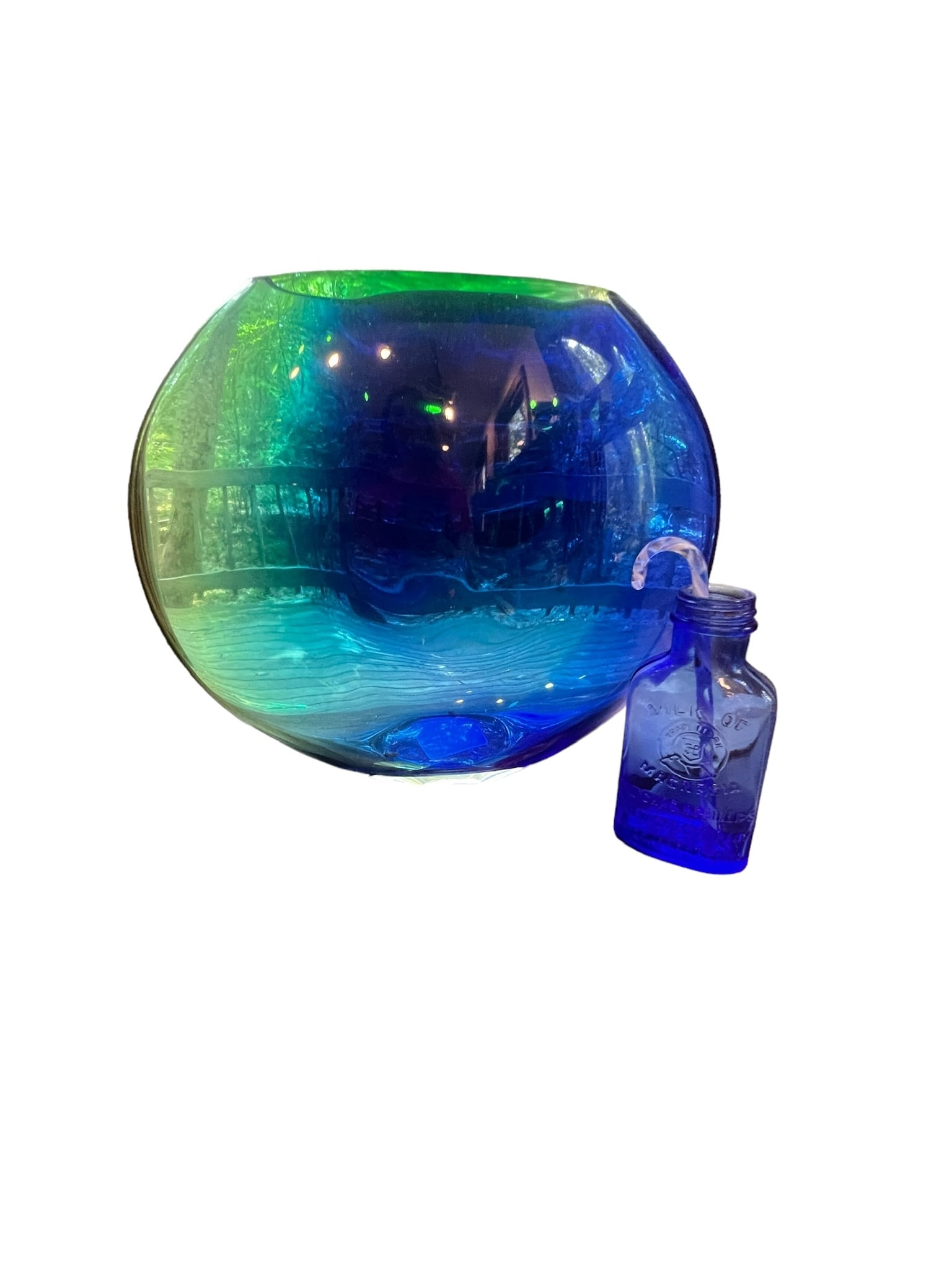 Lot of Blue Glass Decor Vase and Bottle: Blue glass lot consisting of a small glass candy cane, 1 Blue glass Milk of Magnesia bottle, and 1 Tuesday Morning blue glass vase. Vase measures 12 inches long x 10.5 inches tall x 2 inches wide. Bot