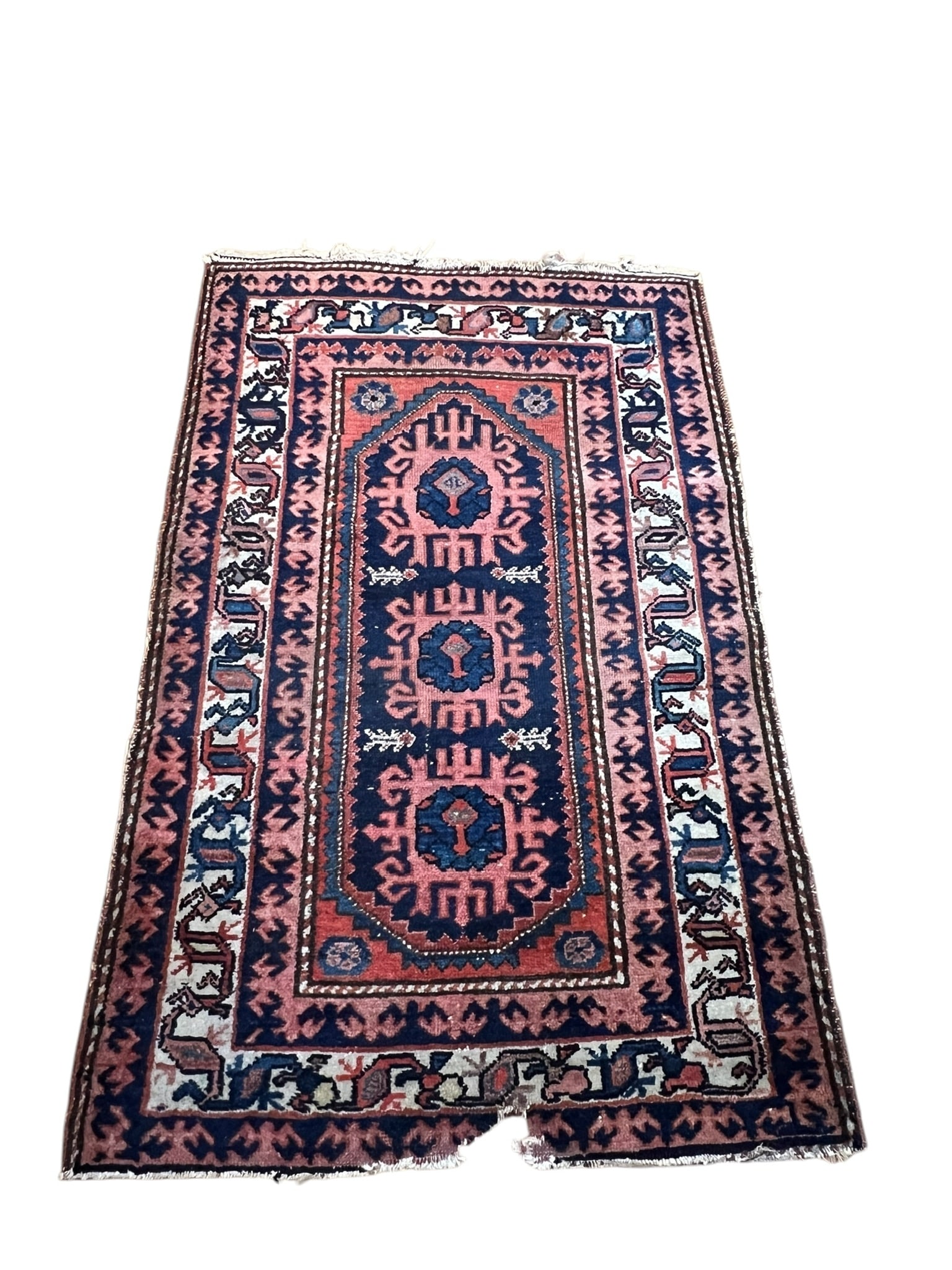 Antique Hand Woven Wool One Way Rug: Antique Hand Woven Wool One Way Rug. Rug is in tones of pink and red. Condition age and use related wear with an area of damage at the end. The other end has use related wear at the edge of the other 