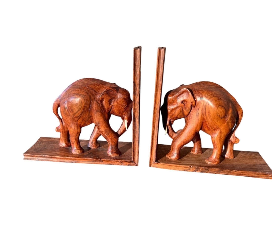 Pair of Mango Wood Elephant Book Ends: Pair of mango-wood elephant book ends. Both in good condition and measuring 9 inches x 9 inches x 4 inches. In House shipping is available for this lot. ****** Please review all photos for further inf