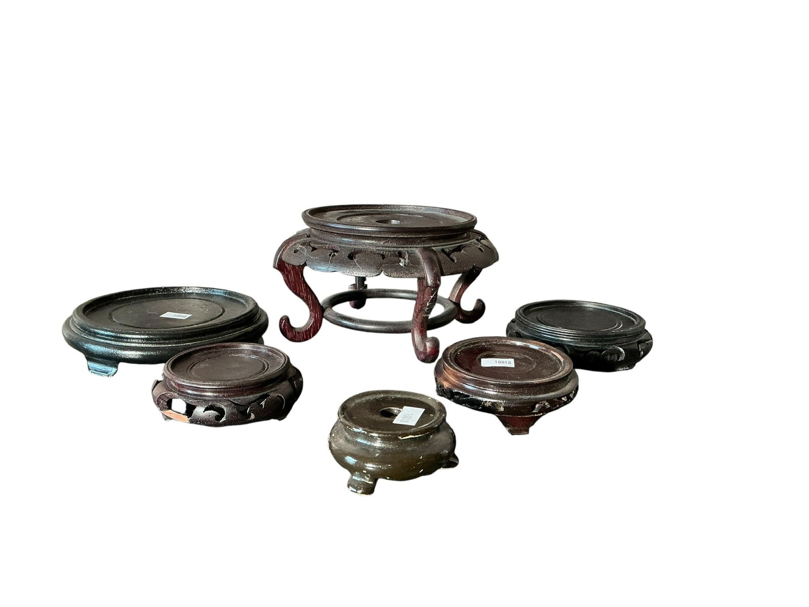 Group of 6 Asian Stands 5 Wood 1 Porcelain: Group of 6 Asian Stands 5 Wood 1 Porcelain. Includes 1 large beautifully carved stand measuring 6 inches across by 4 1/2 inches tall, one measuring 1.5 inches tall x 2 1/4 inches, one measuring 1 inch