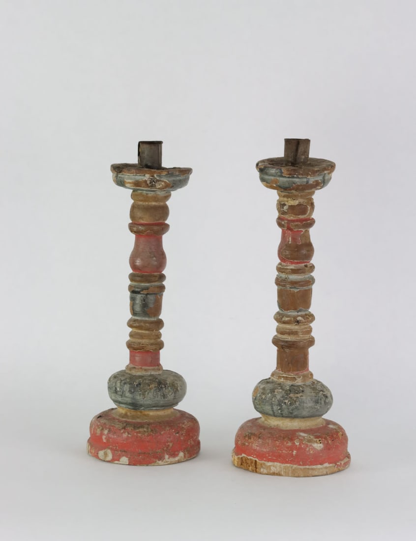 A pair of candlesticks, 18th Century: Polychrome paint and turned wood. width11 cm height32 cm