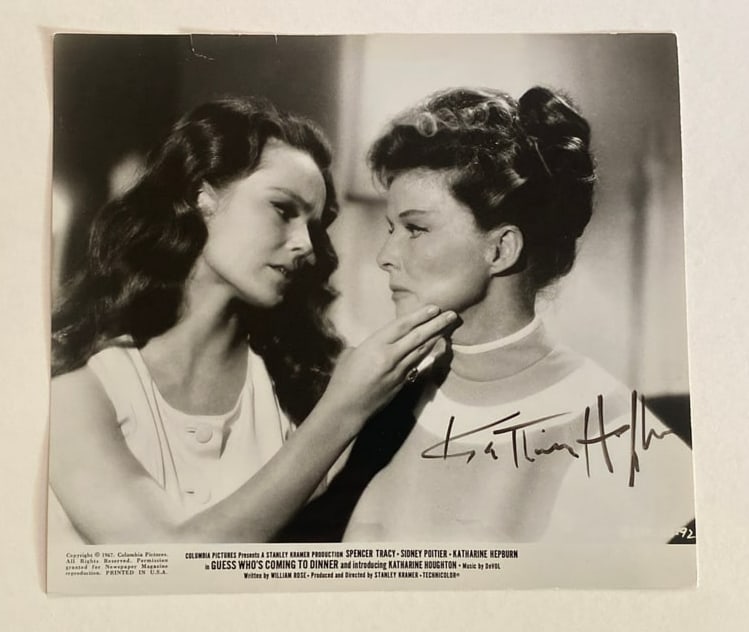 Kathrine Hepburn Autographed Guess Who's Coming to Dinner Movie Photo: This is a striking 8x10 autographed photo of Katharine Hepburn from the iconic film Guess Who's Coming to Dinner. Known for her powerful performances and timeless grace, Hepburn shines in this black-a