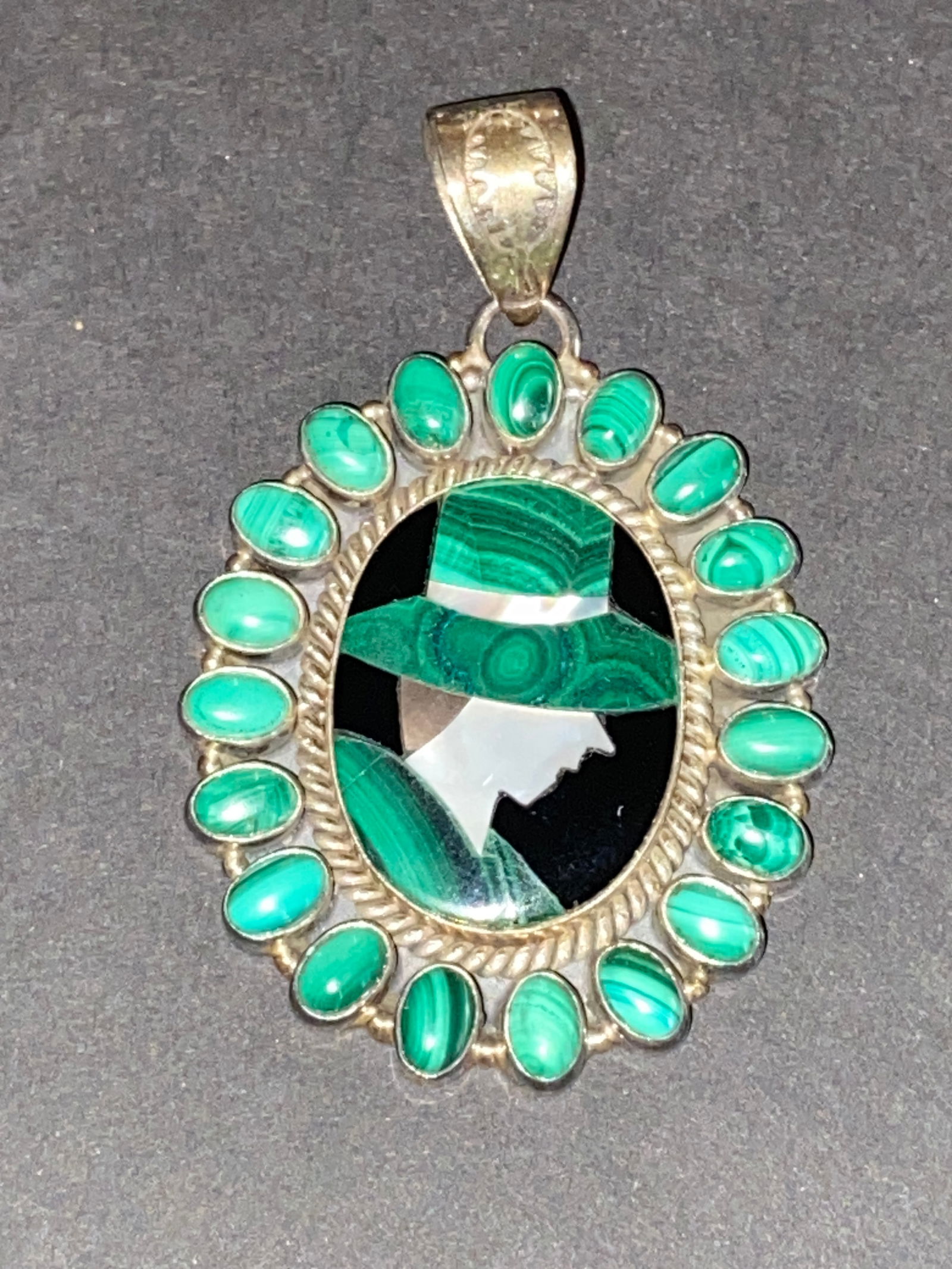 Antique Malachite & Silver Brooch: Elegant antique brooch featuring polished malachite set in hand-worked silver. The green banded stone was prized for its beauty and believed protective powers. A refined piece of vintage jewelry with