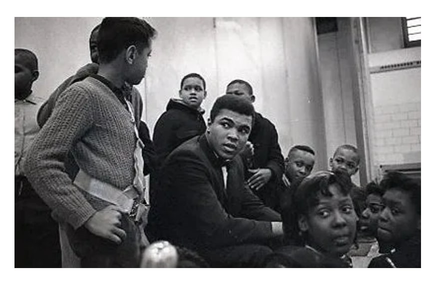 Original Cassius Clay Muhammad Ali Howard Bingham Photo Negative: Original vintage photographic negative by renowned photographer Howard Bingham featuring a young Muhammad Ali—still widely known at the time as Cassius Clay—seated among a group of children