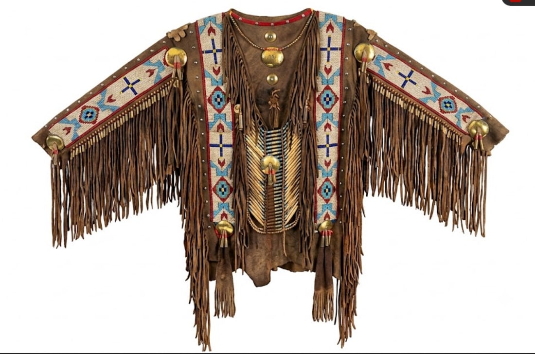1930's Sioux Native American Buckskin Warrior Ceremonial Jacket: This exceptional piece is a significant example of Early 20th Century Plains Indian artistry, dating to approximately the 1930s. Crafted during a pivotal era of cultural preservation, this jacket was