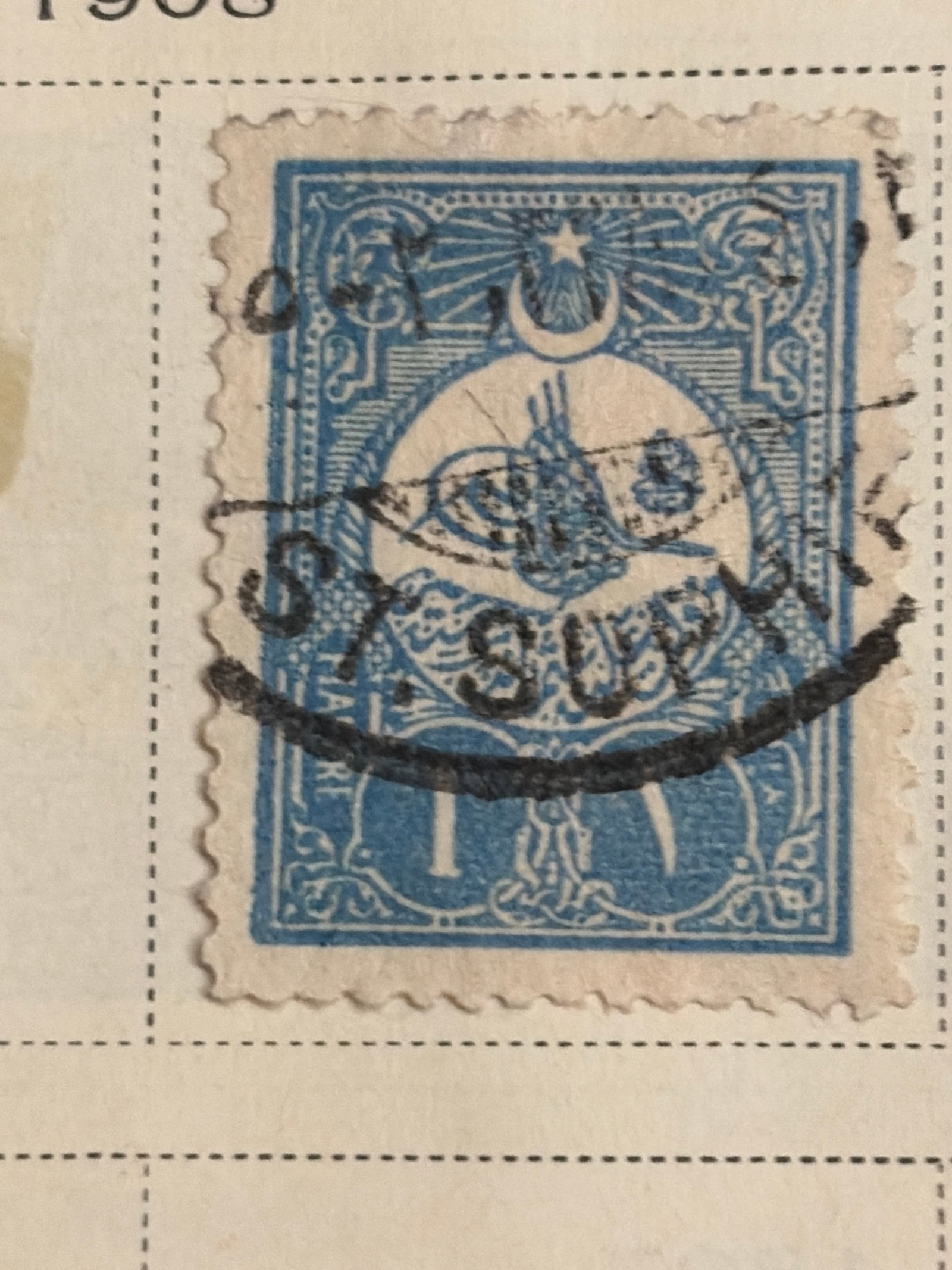 1908 Turkey Ottoman Empire One-Piastre Blue Used Stamp: 1908 Ottoman Empire one-piastre blue postage stamp featuring the imperial tughra, crescent and star within an ornate frame. The stamp has a prominent circular black postal cancellation. The stamp is n