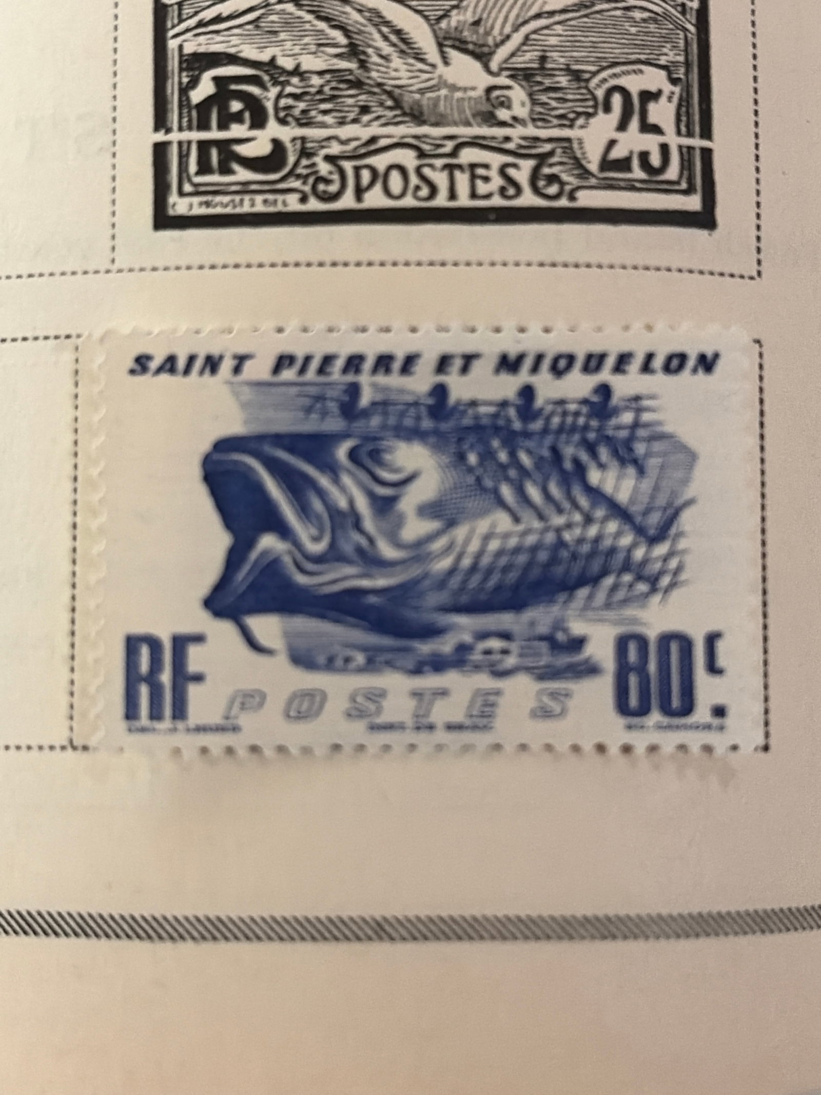 Vintage Saint Pierre and Miquelon Coastal Landscape Stamp: Single Saint Pierre and Miquelon stamp featuring a coastal rock formation, small boat, and RF French Republic inscription. No clear postal cancellation is visible in the photograph. The stamp is not m