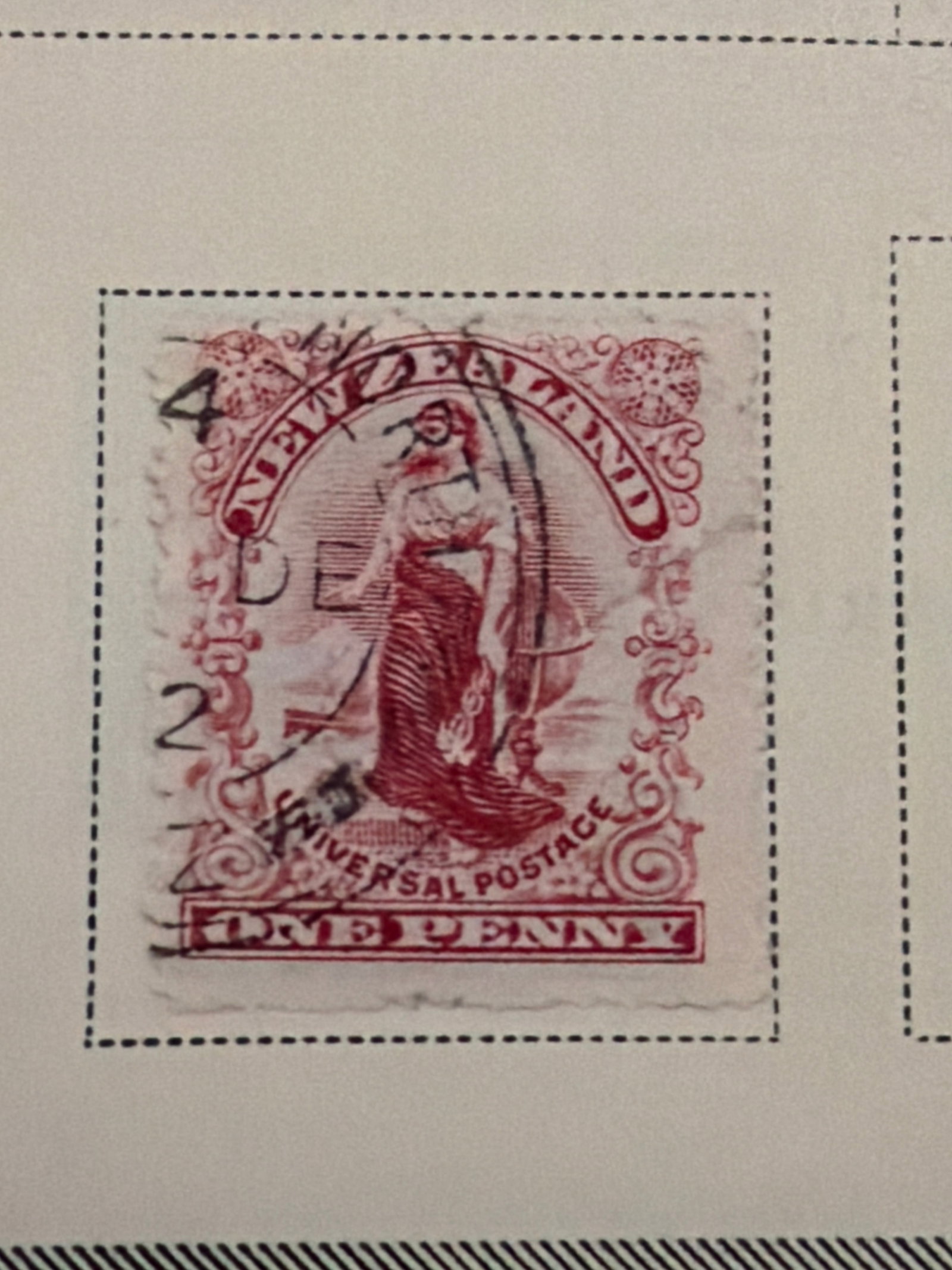 1901 New Zealand Universal Penny Postage Used Stamp: Single rose-colored New Zealand Universal Penny Postage stamp featuring an allegorical female figure. The stamp displays a prominent postal cancellation. The stamp is not mounted or adhered to the alb