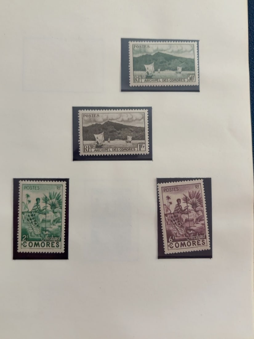 Comoros Islands Boats and Native Life Stamp Group: Four vintage Archipel des Comores postage stamps depicting sailing vessels and island life, including 50c, 1fr, 2fr and 6fr denominations. Stamps appear unused and are mounted on album page; gum and
